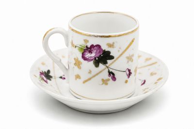 une tasse et une soucoupe blanches ornées de fleurs violettes