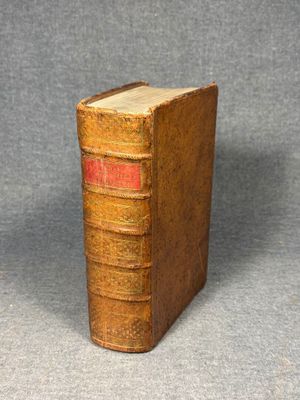 an old book sitting on top of a table next to a gray background