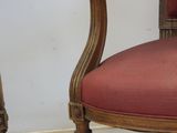 a chair with a red upholstered seat next to a chair with a red upholstered seat