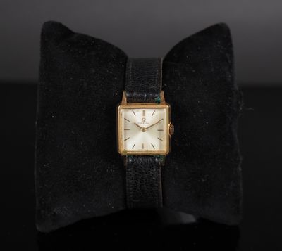 a close up of a watch with a bow tie on a table
