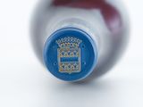 a close up of a bottle of wine on a white surface
