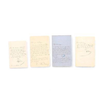 trois vieux papiers sont alignés les uns à côté des autres sur une surface blanche