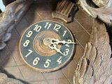a clock that is sitting on a table with a bird on it