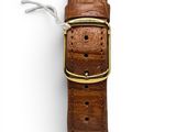 a close up of a brown leather watch strap on a white surface