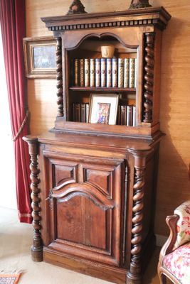 a wooden cabinet with books on top of it in a living room