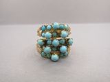 Gros plan sur une bague en or ornée de turquoises