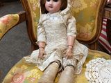 a doll that is sitting on a chair in a room