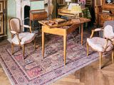 un salon avec une cheminée et un tapis au sol
