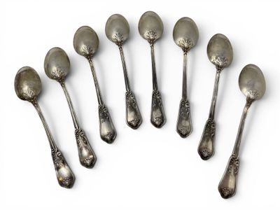 six silver spoons are arranged in a circle on a white surface