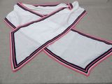 two white towels with pink and blue trims on a bed