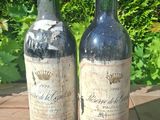 two bottles of wine sitting on a wooden table