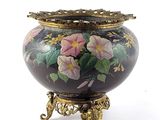 a vase with flowers painted on it sitting on a stand
