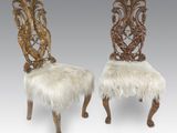 une paire de chaises sculptées dont les assises sont recouvertes de peau de mouton