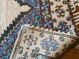 a rug on the floor next to a pillow on the floor