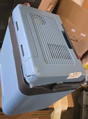 une valise bleue posée sur une pile de cartons