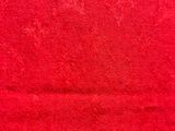 the red towel is on a white surface with a black background