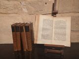 three books sitting on a table next to a cross