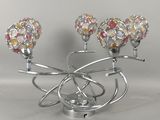 un bougeoir en argent surmonté de trois boules en verre