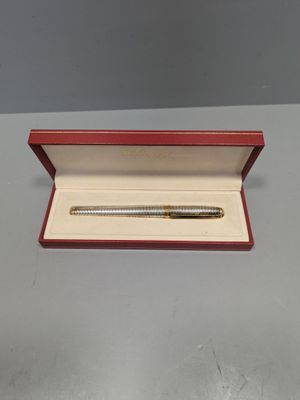 un gros plan d'un stylo dans une boîte rouge posée sur une table