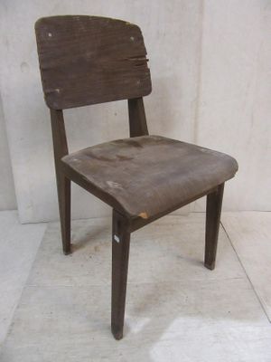 une chaise en bois posée sur un sol carrelé