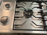 a stainless steel stove top with four burners on it