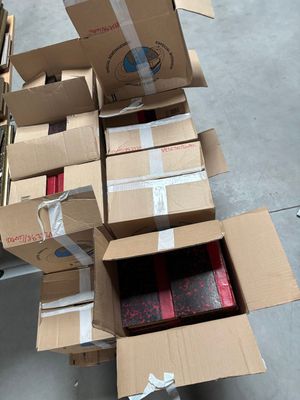un carton rempli de boîtes posé par terre