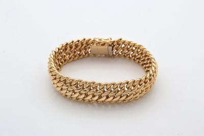 un bracelet à chaîne en or avec un fermoir sur fond blanc