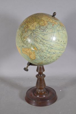 un globe antique posé sur un socle en bois, sur fond blanc