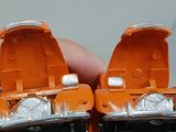 two orange toy cars that are sitting next to each other