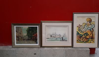 trois tableaux encadrés posés sur une corniche devant un mur rouge