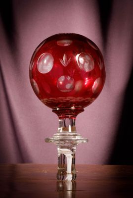 une boule de verre rouge posée sur une table en bois