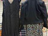 two dresses hanging on a wire rack in a room