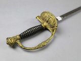 an old sword with a gold handle on a white surface