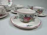 many cups and saucers sitting on a table