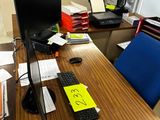 un bureau sur lequel se trouvent un ordinateur, un clavier, une souris et des papiers