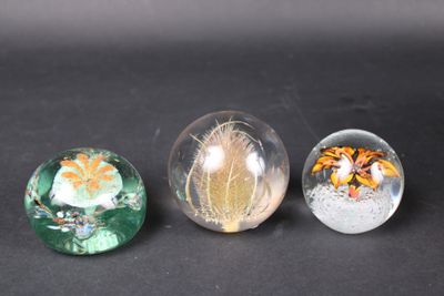 three glass marbles sitting on top of a table next to each other