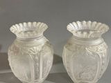 deux vases blancs posés l'un à côté de l'autre sur une table