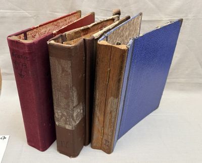 several old books are lined up in a row on a table