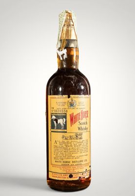 une vieille bouteille de whisky posée sur une table