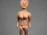 a wooden statue of a man standing on a pedestal