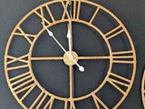 two clocks on the wall with roman numerals on each of them