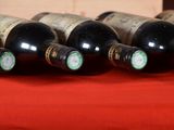 several bottles of wine are lined up on a red table