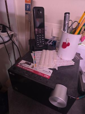 un pot rempli de crayons et un téléphone portable posés sur un bureau