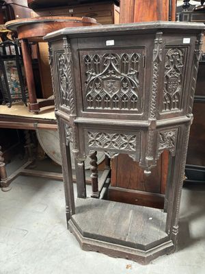 une armoire d'angle ancienne en bois, ornée de sculptures élaborées sur les côtés