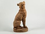 statue of a dog sitting on a pedestal on a white background