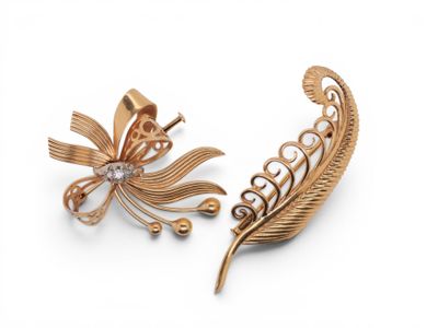 two gold tone brooches with pearls and leaves on them