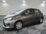 une Toyota Yaris grise garée sur un sol en carrelage à damier