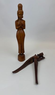 figurine en bois représentant une femme et un lézard sur fond blanc