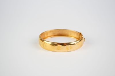 a close up of a gold ring on a white surface