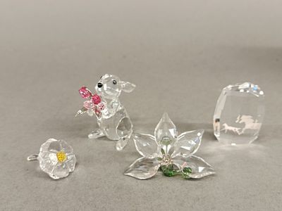 three crystal figurines of mice and flowers on a gray surface
